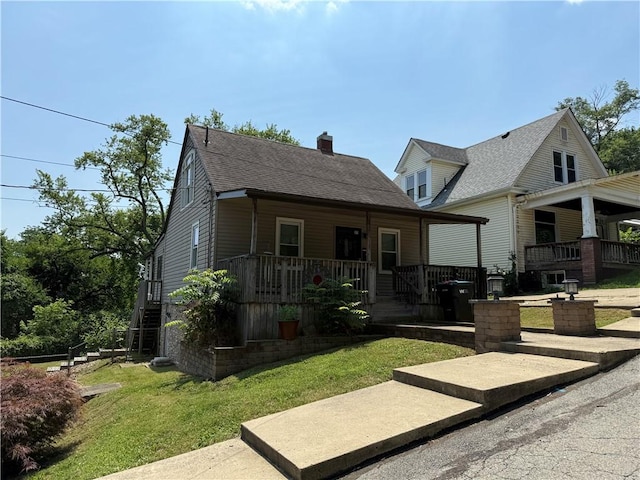 1119 Stewart St, Tarentum, PA 15084 - back of property featuring covered porch, a yard, a chimney, and a shingled roof