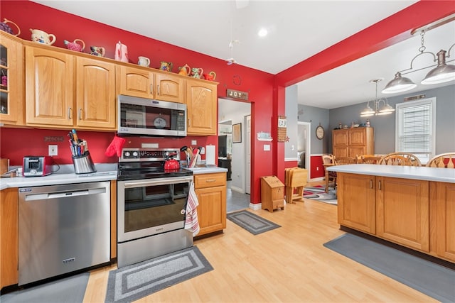 332 S Chestnut St, Scottdale, PA 15683 - kitchen with appliances with stainless steel finishes, light wood finished floors, light countertops, glass insert cabinets, and decorative light fixtures
