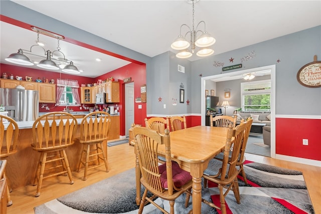 332 S Chestnut St, Scottdale, PA 15683 - dining area featuring light wood-style flooring, a chandelier, and a ceiling fan