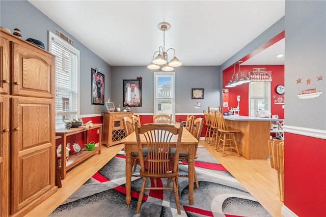 332 S Chestnut St, Scottdale, PA 15683 - dining area featuring light wood finished floors, a chandelier, and a wainscoted wall