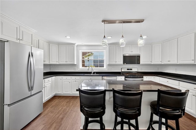 235 Telegraph Rd, Luzerne Twp, PA 15417 - kitchen featuring appliances with stainless steel finishes, dark countertops, dark wood finished floors, white cabinets, and recessed lighting