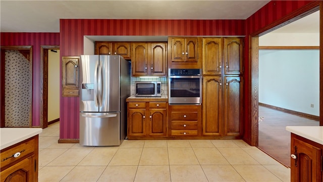 8410 Windsor Beach Ct, Harborcreek Twp, PA 16511 - kitchen with stainless steel appliances, light countertops, brown cabinets, and wallpapered walls