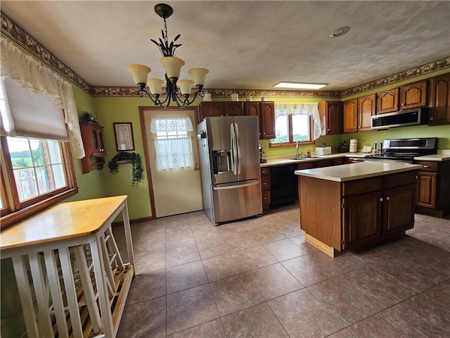 323 Hoon Rd, Oakland Twp, PA 16001 - kitchen featuring appliances with stainless steel finishes, light countertops, a center island, a chandelier, and decorative light fixtures