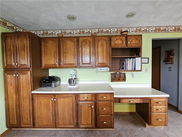 323 Hoon Rd, Oakland Twp, PA 16001 - kitchen with built in study area, light countertops, brown cabinets, and tile patterned floors