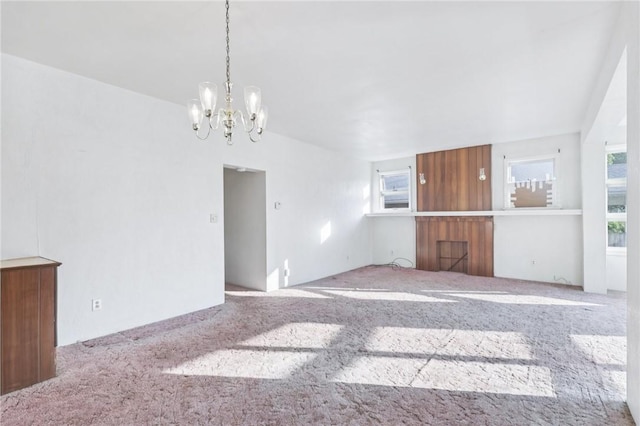 357 Keystone Dr, New Kensington, PA 15068 - unfurnished living room featuring a chandelier, plenty of natural light, and carpet flooring
