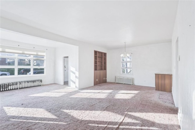 357 Keystone Dr, New Kensington, PA 15068 - unfurnished living room with radiator heating unit, a chandelier, and carpet flooring