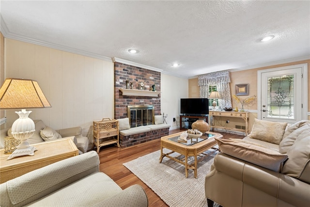 511 Brunswick Dr, Hempfield Twp, PA 15601 - living room with ornamental molding, wood finished floors, a fireplace, a textured ceiling, and recessed lighting