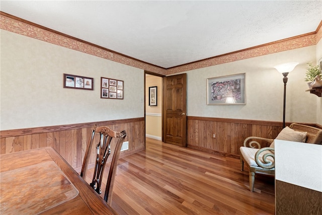 511 Brunswick Dr, Hempfield Twp, PA 15601 - living area featuring wainscoting, wood finished floors, ornamental molding, and wooden walls