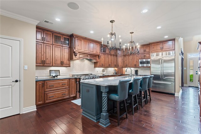 3111 Edelweiss Ct Ste 201, Adams Twp, PA 16046 - kitchen featuring built in appliances, brown cabinetry, a chandelier, tasteful backsplash, and a breakfast bar area