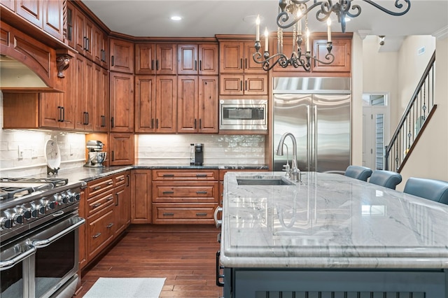 3111 Edelweiss Ct Ste 201, Adams Twp, PA 16046 - kitchen featuring built in appliances, dark stone counters, dark wood-style floors, a chandelier, and a kitchen island with sink