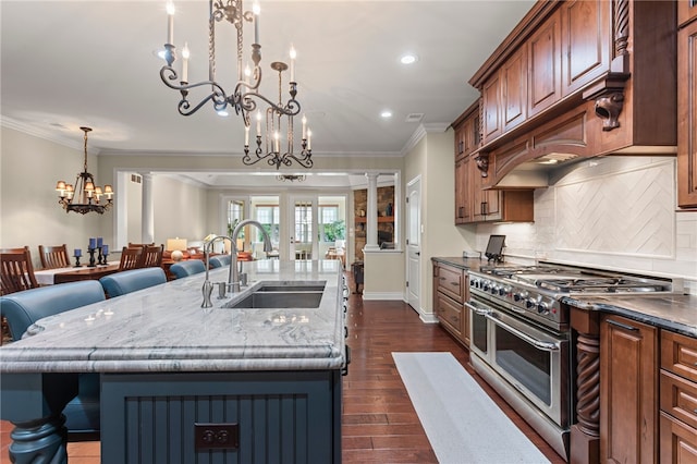 3111 Edelweiss Ct Ste 201, Adams Twp, PA 16046 - kitchen featuring range with two ovens, a chandelier, crown molding, a breakfast bar, and dark wood finished floors