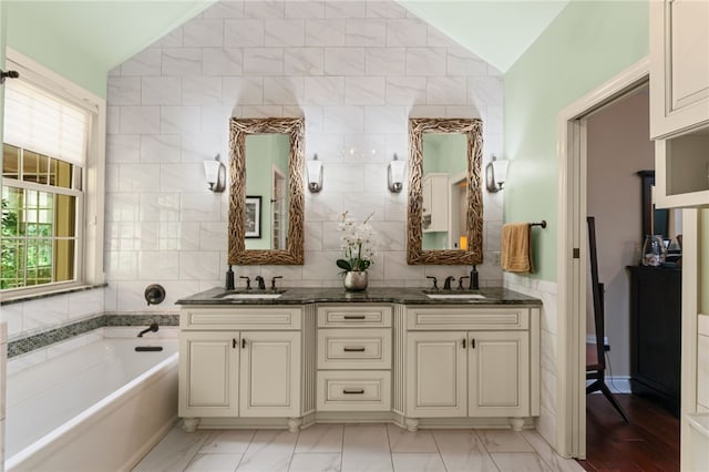 3111 Edelweiss Ct Ste 201, Adams Twp, PA 16046 - bathroom with vaulted ceiling, double vanity, a garden tub, marble finish floors, and tile walls