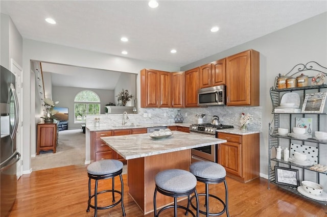 774 Norwegian Spruce Dr, Adams Twp, PA 16046 - kitchen with stainless steel appliances, a kitchen breakfast bar, light wood-type flooring, a center island, and decorative backsplash