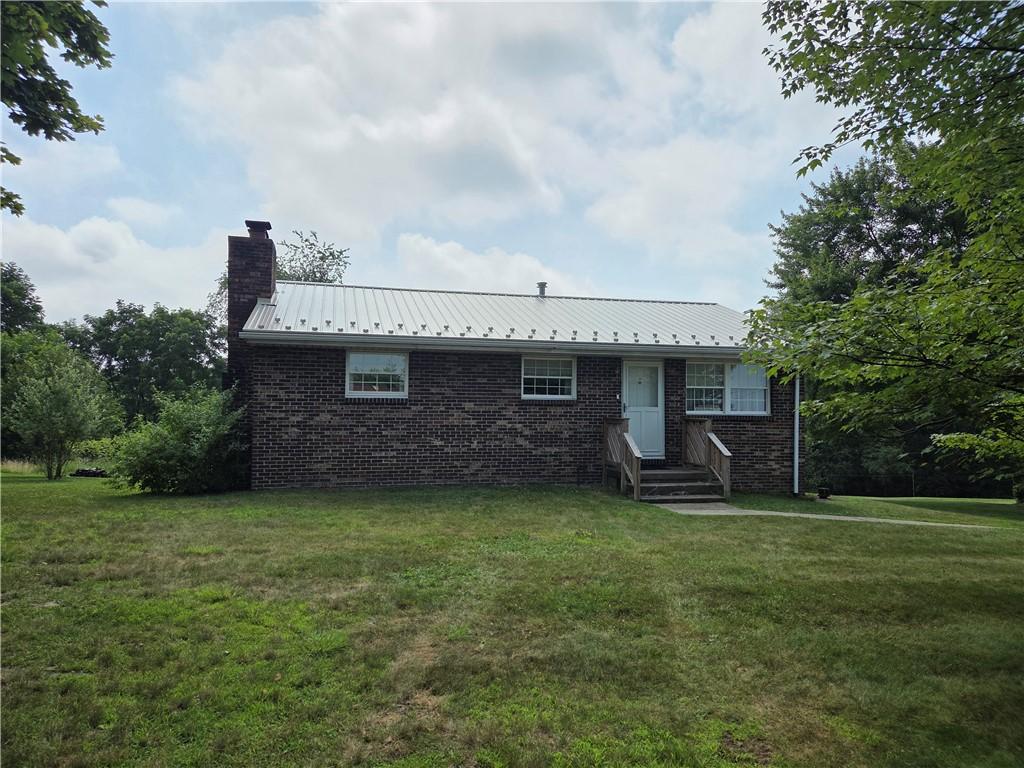 317 Highview Cir, New Sewickley Twp, PA 15042 - single story home with a chimney, a front lawn, brick siding, and a metal roof