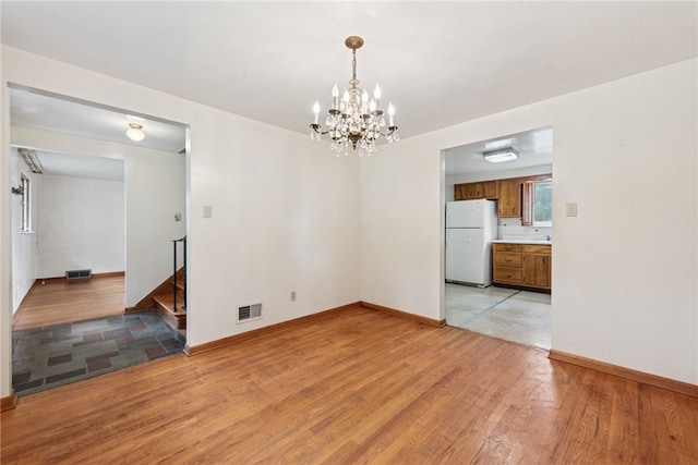 1920 Cheryl Dr, North Huntingdon, PA 15642 - empty room with a chandelier, light wood-style flooring, and stairs