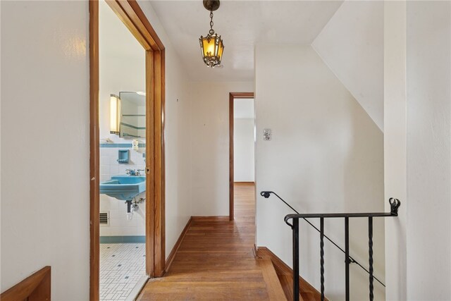 1920 Cheryl Dr, North Huntingdon, PA 15642 - hall featuring an upstairs landing, wood finished floors, and a chandelier
