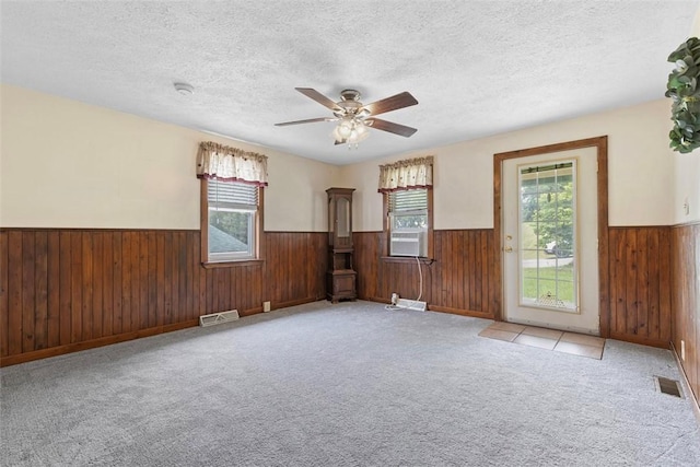 3914 38th St, Pulaski Twp, PA 15066 - empty room with a wainscoted wall, wood walls, a textured ceiling, a ceiling fan, and carpet flooring