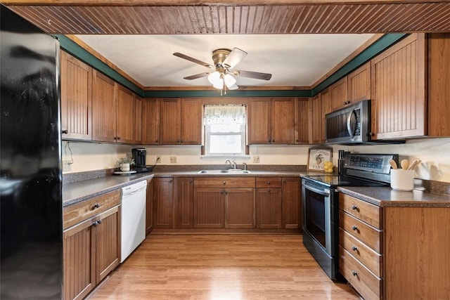 3914 38th St, Pulaski Twp, PA 15066 - kitchen featuring stainless steel appliances, dark countertops, brown cabinets, ceiling fan, and light wood finished floors