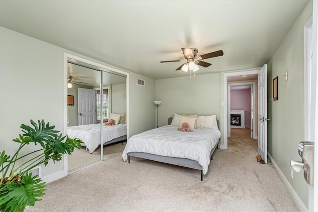 115 Nursery Rd, Forward Twp, PA 16053 - bedroom featuring light colored carpet, a ceiling fan, a closet, and a lit fireplace