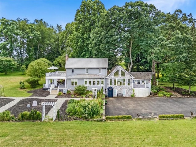 115 Nursery Rd, Forward Twp, PA 16053 - rear view of property with a chimney, a lawn, a metal roof, stone siding, and view of wooded area