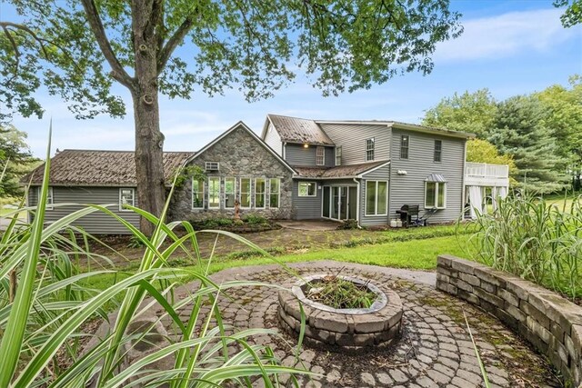 115 Nursery Rd, Forward Twp, PA 16053 - back of property featuring an outdoor fire pit, a patio, stone siding, and a lawn