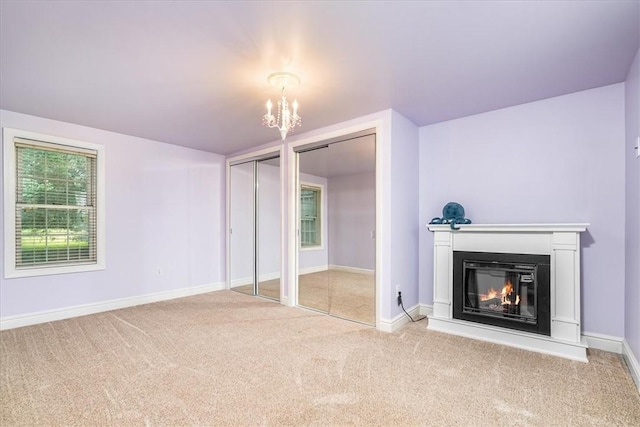 115 Nursery Rd, Forward Twp, PA 16053 - unfurnished living room featuring carpet flooring, a chandelier, and a glass covered fireplace