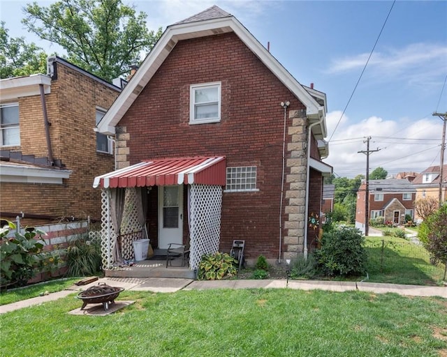 2913 Willett Rd, Brentwood, PA 15227 - view of front of property with an outdoor fire pit, a front lawn, and brick siding
