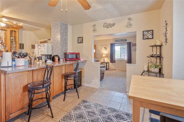 2913 Willett Rd, Brentwood, PA 15227 - kitchen featuring a ceiling fan, stainless steel microwave, light tile patterned floors, and light carpet