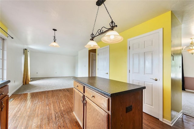 538 Bluegrass Dr, Canonsburg, PA 15317 - kitchen featuring dark countertops, a center island, hanging light fixtures, dark colored carpet, and dark wood-style floors
