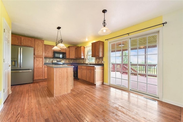 538 Bluegrass Dr, Canonsburg, PA 15317 - kitchen featuring black appliances, light wood-style floors, tasteful backsplash, dark countertops, and a kitchen island