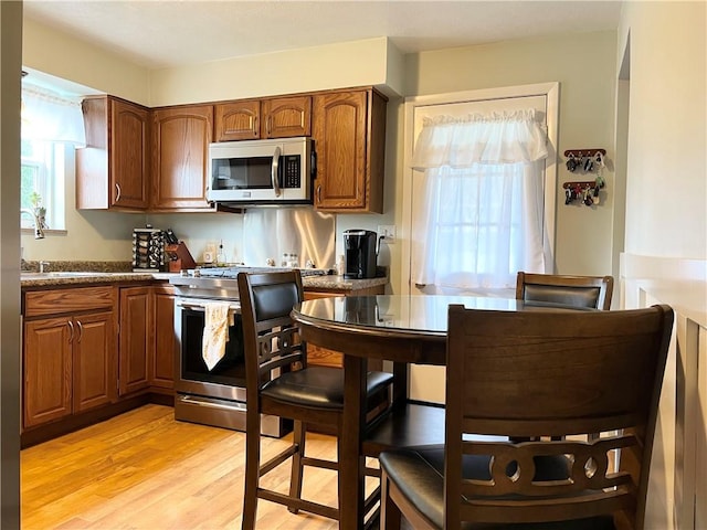 1069 Martin Ave, New Kensington, PA 15068 - kitchen featuring stainless steel appliances, light wood-style flooring, and brown cabinetry