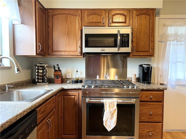 1069 Martin Ave, New Kensington, PA 15068 - kitchen featuring stainless steel appliances, brown cabinetry, and light countertops