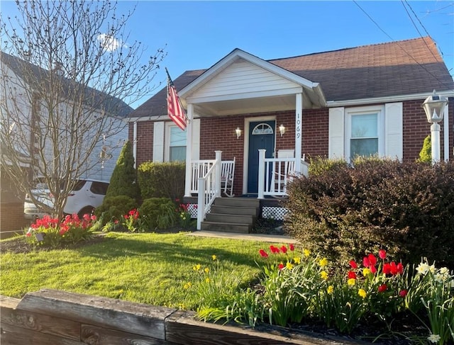 1069 Martin Ave, New Kensington, PA 15068 - view of front of property with brick siding, a front yard, covered porch, and a shingled roof