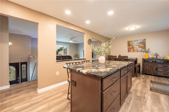 43 Dover Rd, Penn Twp, PA 15642 - kitchen featuring light wood finished floors, a kitchen bar, a kitchen island, dark stone countertops, and recessed lighting