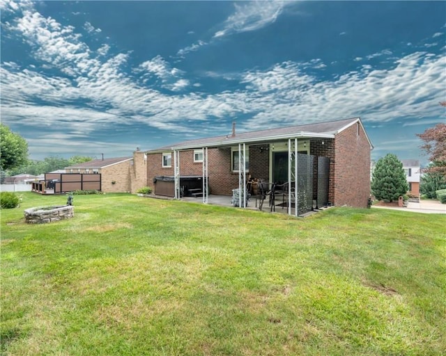 43 Dover Rd, Penn Twp, PA 15642 - back of property with a hot tub, a patio area, an outdoor fire pit, and brick siding