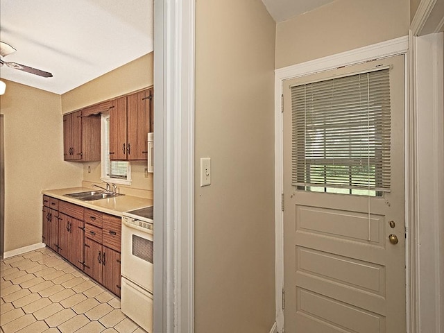 881 Ridge Rd, Harmony Twp, PA 15003 - kitchen featuring white range with electric stovetop, brown cabinets, light countertops, ceiling fan, and light tile patterned flooring