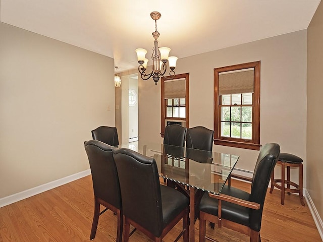 881 Ridge Rd, Harmony Twp, PA 15003 - dining area featuring a chandelier, wood finished floors, and a baseboard heating unit