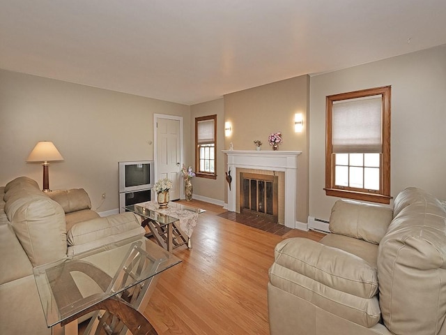 881 Ridge Rd, Harmony Twp, PA 15003 - living area featuring baseboard heating, light wood-style flooring, and a fireplace with flush hearth