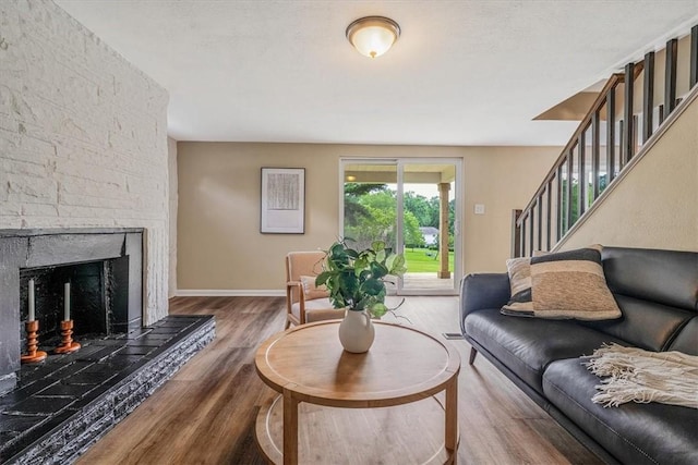 7321 Ringertown Rd, Murrysville, PA 15632 - living area with wood finished floors, a fireplace with raised hearth, and stairs