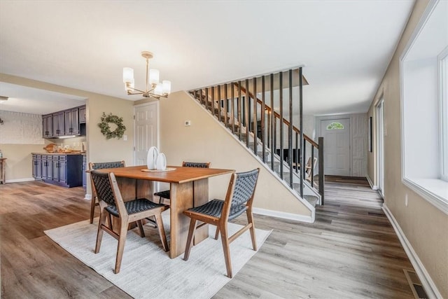 7321 Ringertown Rd, Murrysville, PA 15632 - dining space with stairs, a chandelier, and light wood finished floors