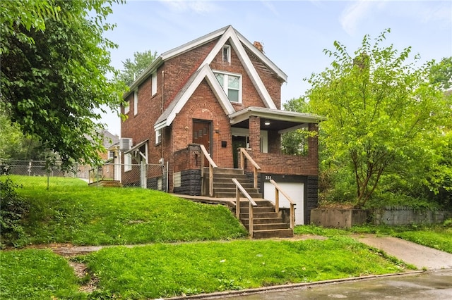 233 E 21st Ave, Munhall, PA 15120 - english style home with brick siding, stairway, an attached garage, a chimney, and covered porch