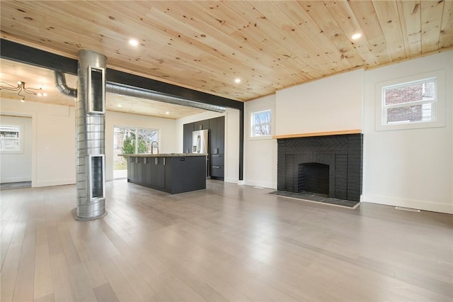 233 E 21st Ave, Munhall, PA 15120 - unfurnished living room with wooden ceiling, wood finished floors, recessed lighting, and a brick fireplace