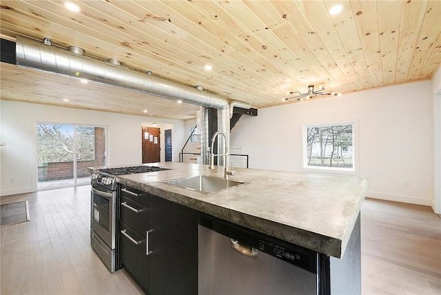 233 E 21st Ave, Munhall, PA 15120 - kitchen featuring appliances with stainless steel finishes, dark cabinets, an island with sink, healthy amount of natural light, and recessed lighting