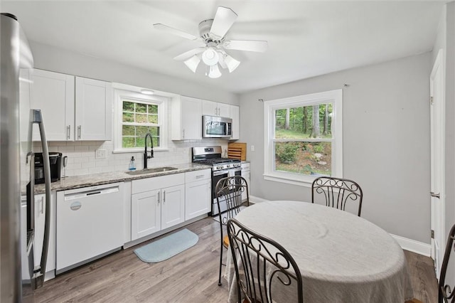 516 Shenango Rd, Chippewa Twp, PA 15010 - kitchen featuring stainless steel appliances, decorative backsplash, white cabinetry, and light stone countertops