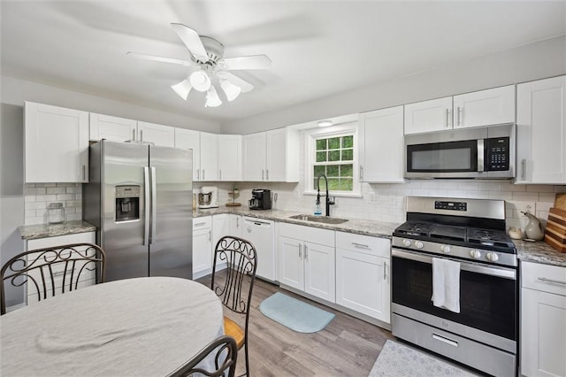516 Shenango Rd, Chippewa Twp, PA 15010 - kitchen with stainless steel appliances, light wood finished floors, white cabinets, and a ceiling fan