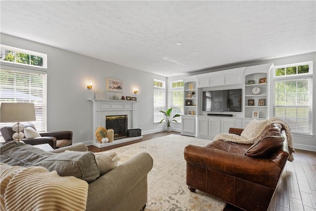 237 Clever Rd, Robinson Twp, PA 15136 - living area featuring wood finished floors, plenty of natural light, a fireplace with raised hearth, and a textured ceiling