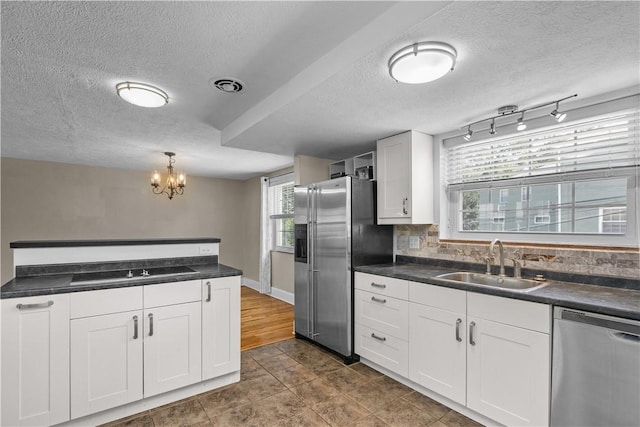 109 Raleigh Ct, Ross Twp, PA 15237 - kitchen featuring appliances with stainless steel finishes, dark countertops, a textured ceiling, white cabinets, and a chandelier
