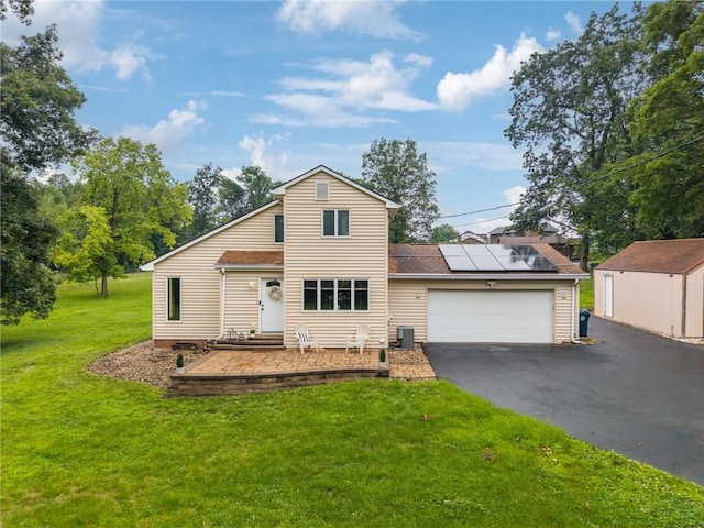 110 Four Seasons Ln, Irwin, PA 15642 - traditional-style home with solar panels, asphalt driveway, a front lawn, and an attached garage