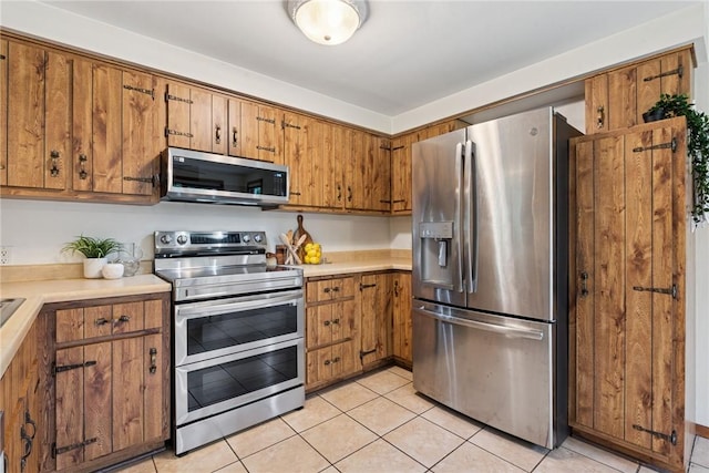 110 Four Seasons Ln, Irwin, PA 15642 - kitchen featuring appliances with stainless steel finishes, brown cabinetry, and light countertops