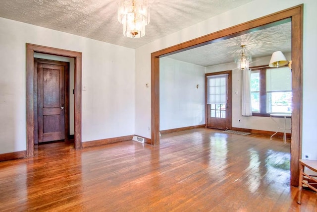 3444 Brodhead Rd, Center Twp, PA 15061 - unfurnished room with a chandelier, wood finished floors, and a textured ceiling